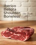Iberico Bellota Shoulder — Boneless displayed on a wooden surface with a signature in the background.