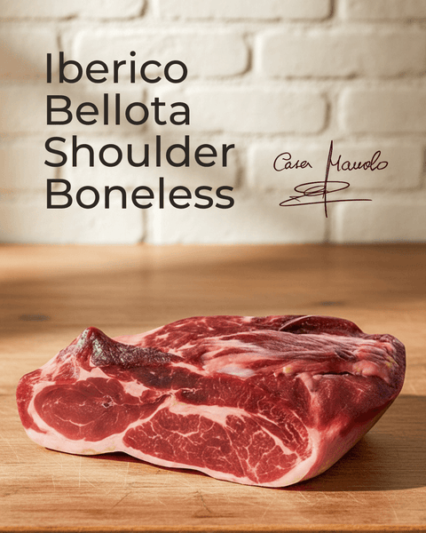 Iberico Bellota Shoulder — Boneless displayed on a wooden surface with a signature in the background.